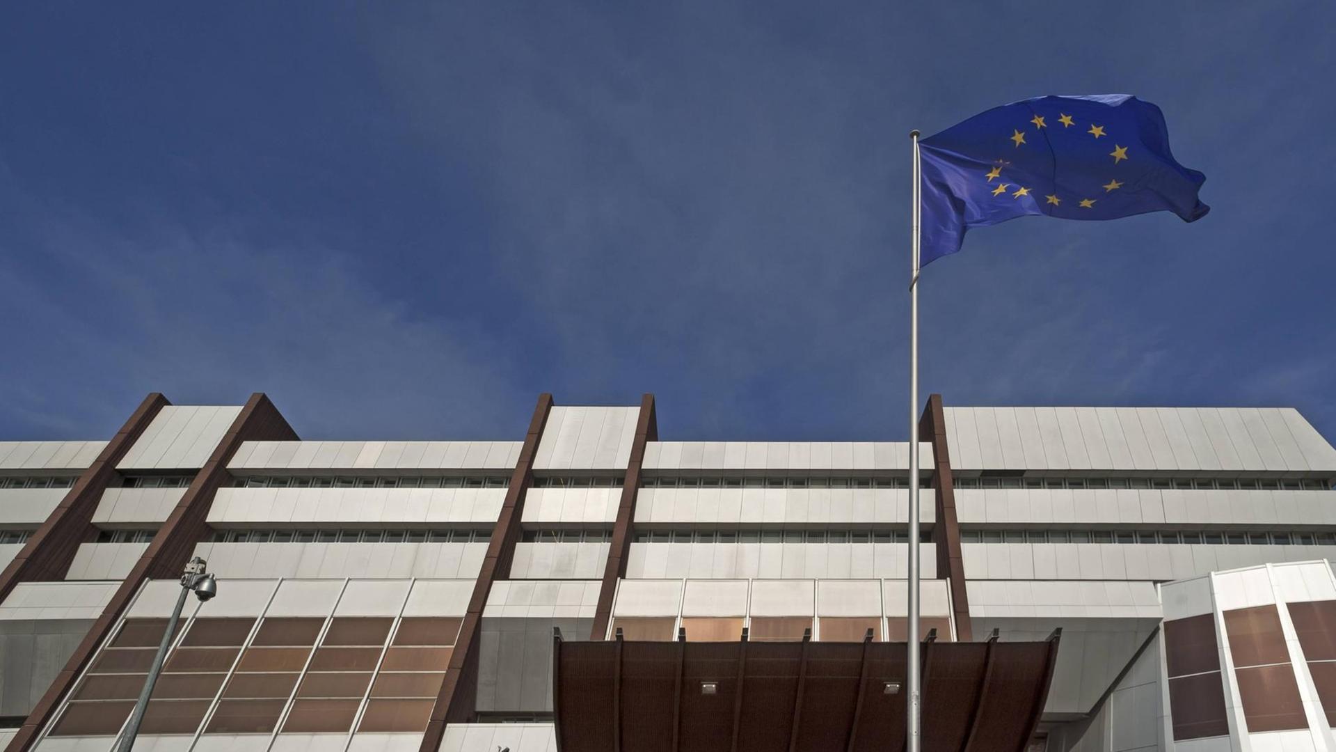 Wehende Europafahne vor dunklem Himmel vor dem Europarat in Straßburg Wehende Europafahne vor dunklem Himmel vor dem Europarat in Straßburg