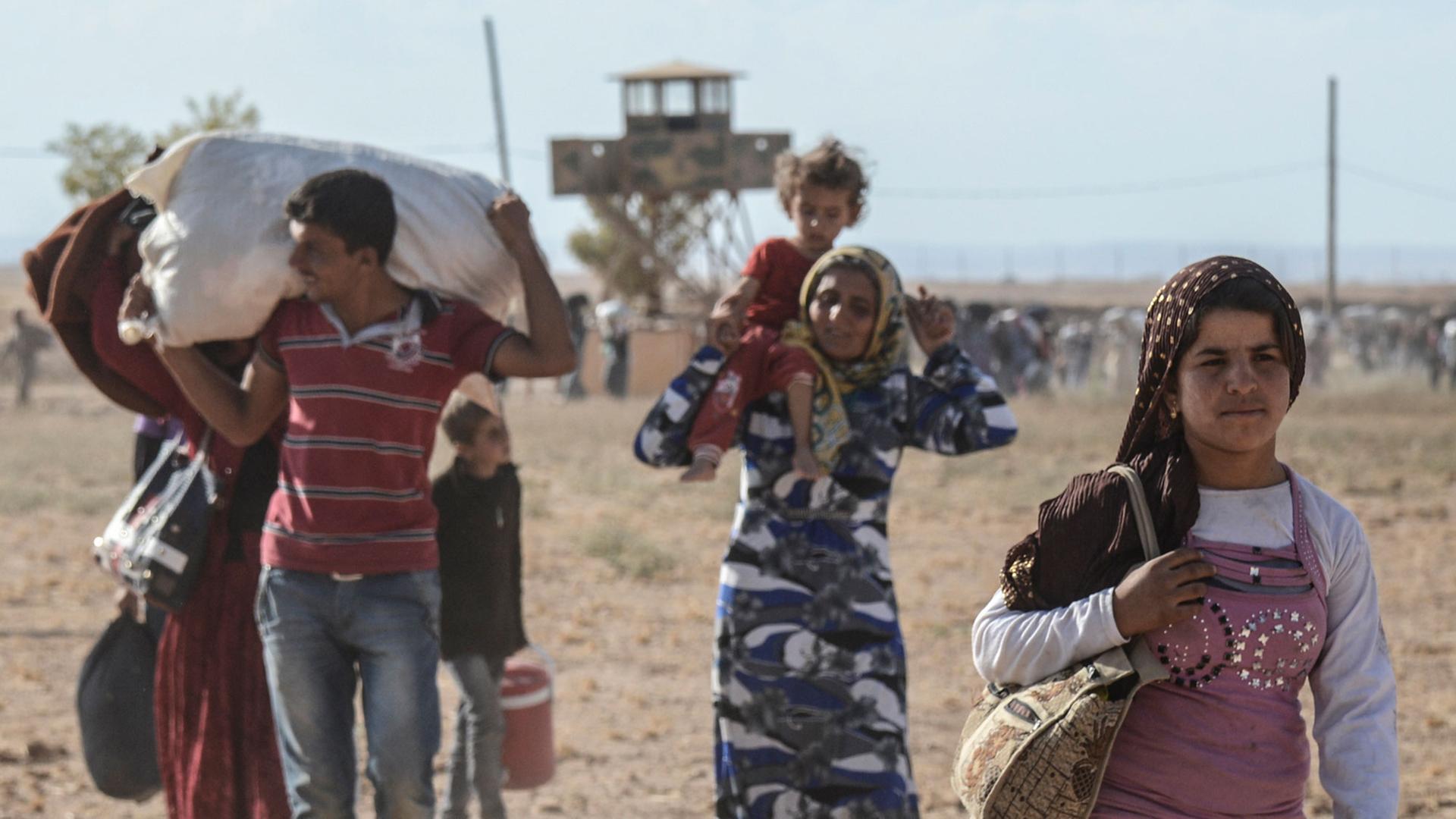Syrische Kurden überqueren die Grenze zur Türkei. Syrische Kurden überqueren die Grenze zur Türkei.