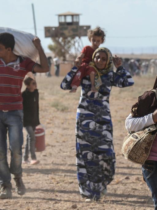 Syrische Kurden überqueren die Grenze zur Türkei.