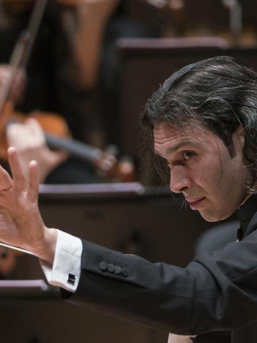 Der Dirigent streckt während seiner Arbeit am Dirigentenpult seine Hand aus. .