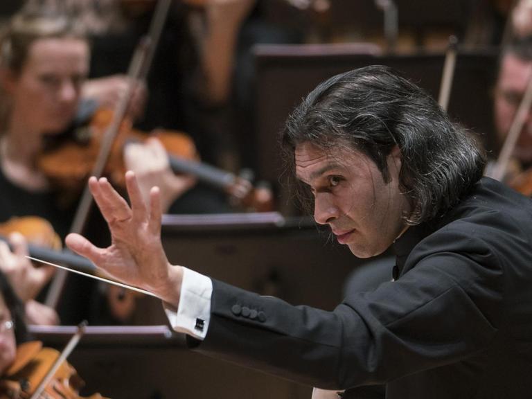 Der Dirigent streckt während seiner Arbeit am Dirigentenpult seine Hand aus. .