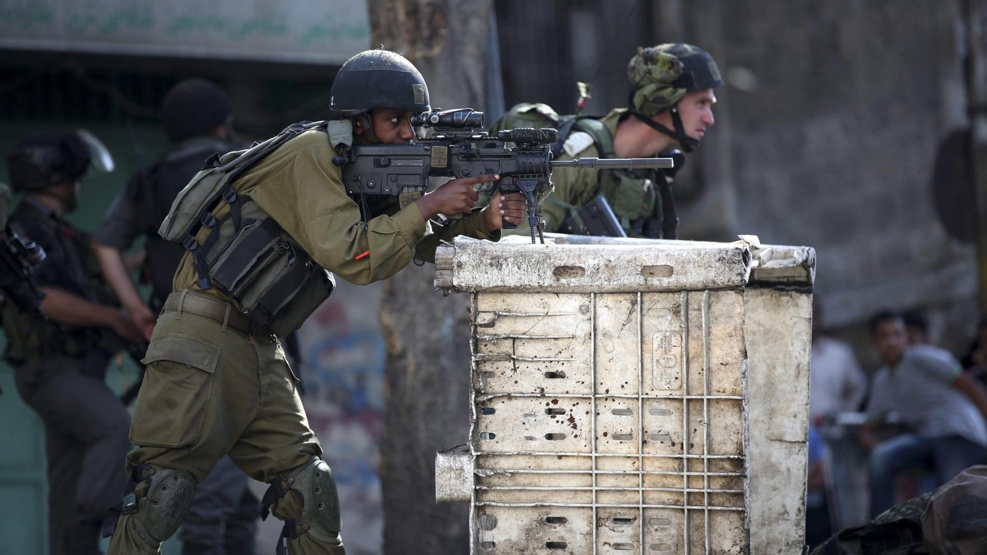 Ein israelischer Soldat mit seiner Waffe in Hebron im Westjordanland. Ein israelischer Soldat mit seiner Waffe in Hebron im Westjordanland.