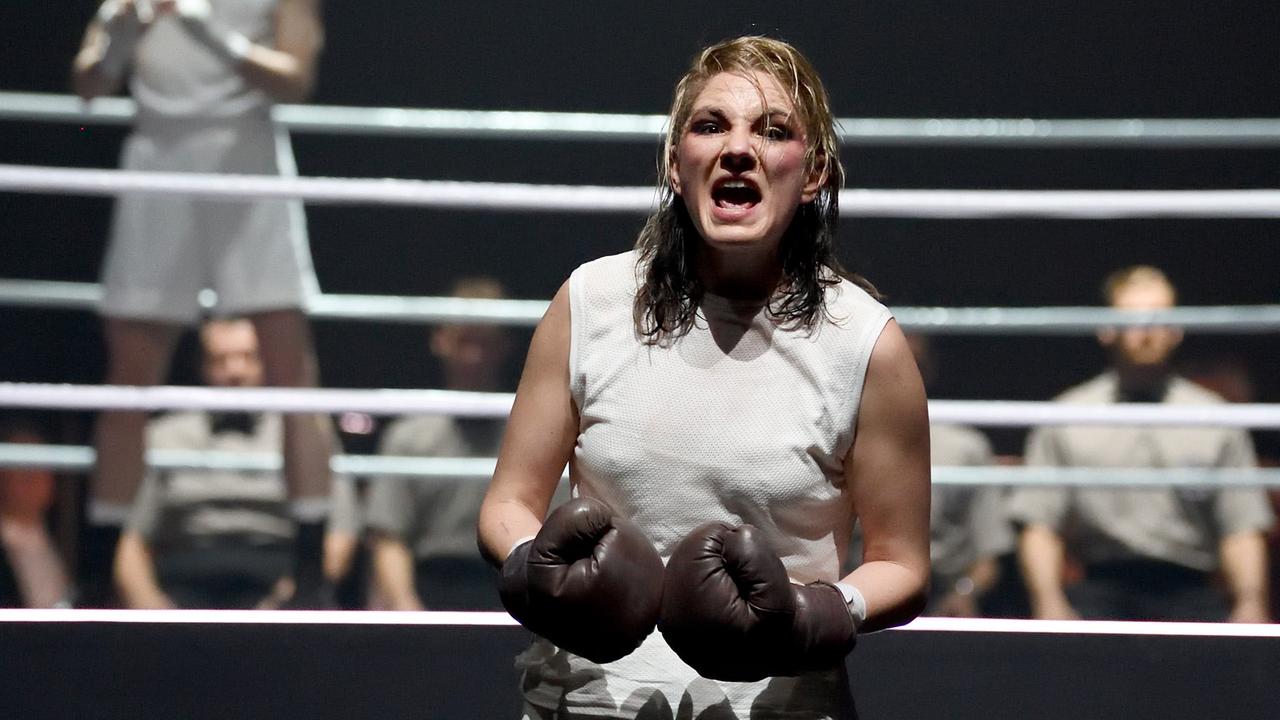 Josephine Köhler mit Boxhandschuhen in kämpferischer Pose vor einem Boxring. Josephine Köhler mit Boxhandschuhen in kämpferischer Pose vor einem Boxring.