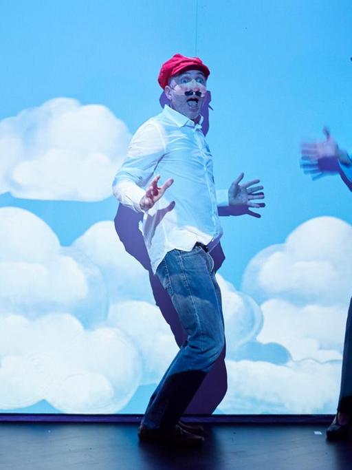 Die Schauspieler Ilja Harjes, Thomas Mehlhorn und Rose Lohmann stehen vor einem Plakat mit Wolken auf einer Bühne