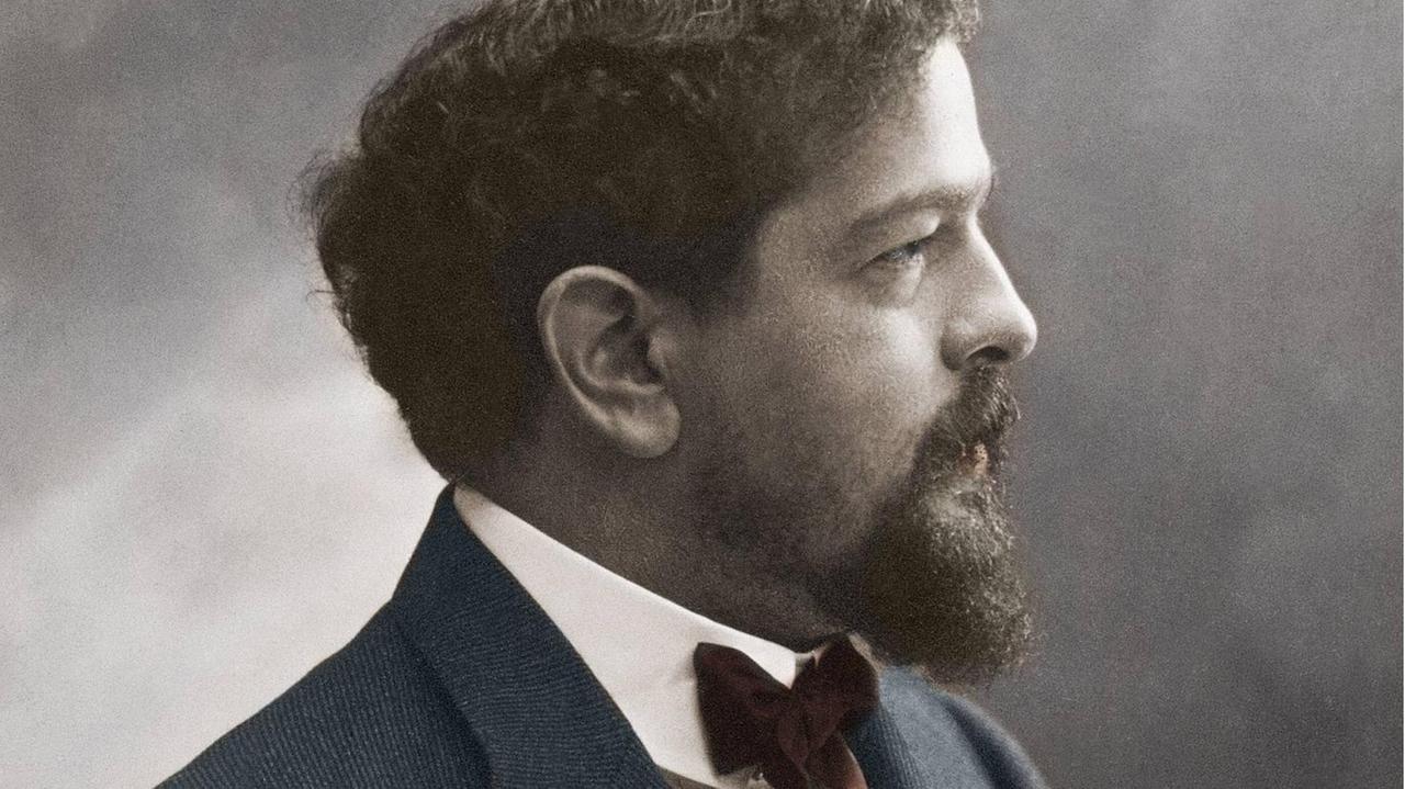 Nachkolorierte Fotografie des Komponisten, der um 1908 mit vollem Haar und Vollbart der Kamera sein Profil zeigt. Nachkolorierte Fotografie des Komponisten, der um 1908 mit vollem Haar und Vollbart der Kamera sein Profil zeigt.