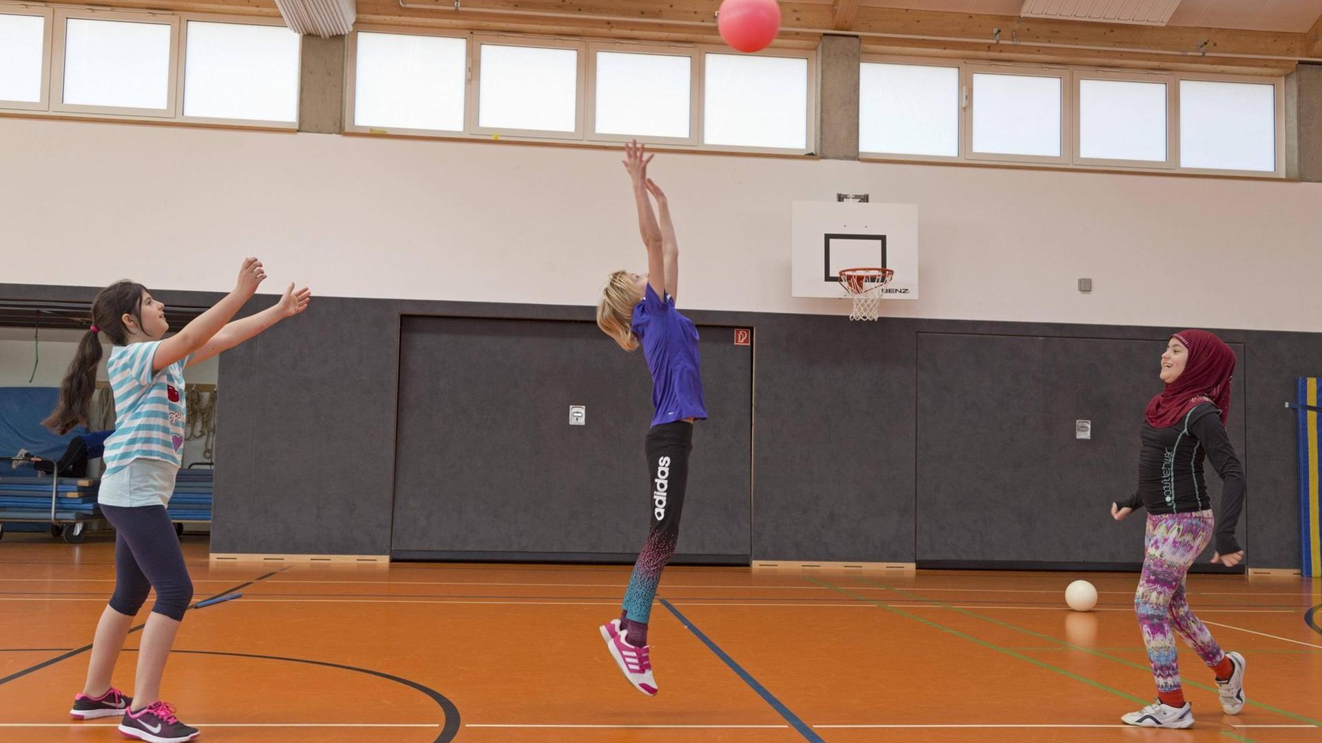 Schülerinnen beim Ballspiel in der Turnhalle, Sportunterricht, Grundschule Schülerinnen beim Ballspiel in der Turnhalle, Sportunterricht, Grundschule