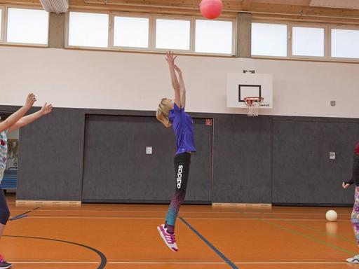 Schülerinnen beim Ballspiel in der Turnhalle, Sportunterricht, Grundschule