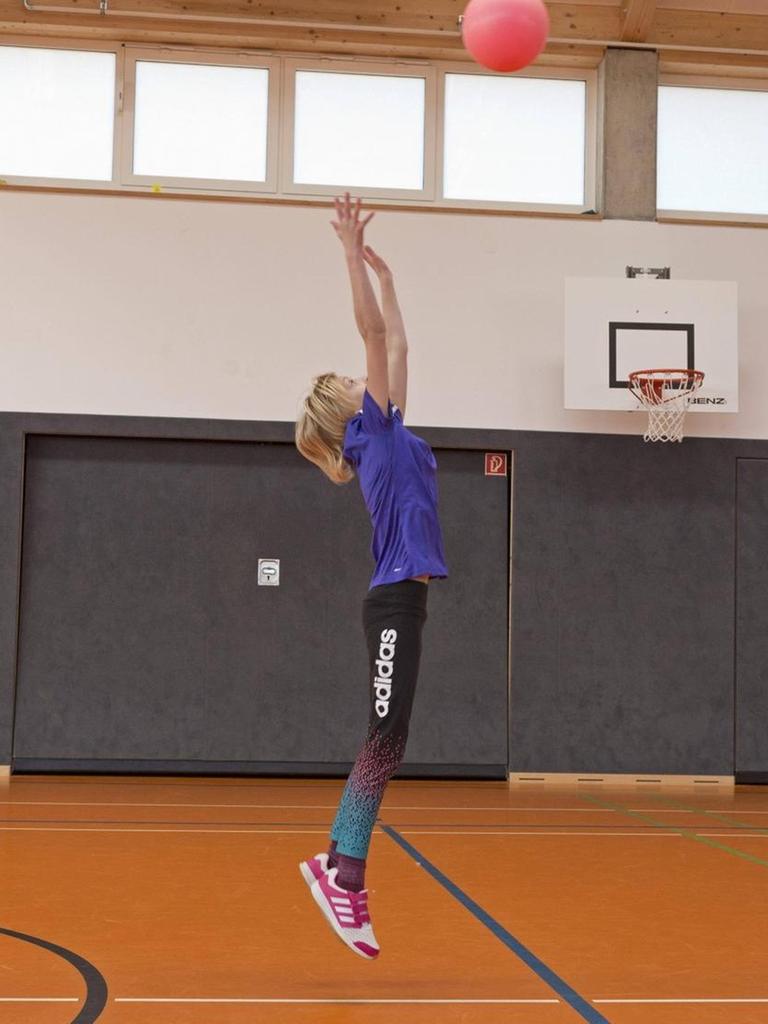 Schülerinnen beim Ballspiel in der Turnhalle, Sportunterricht, Grundschule