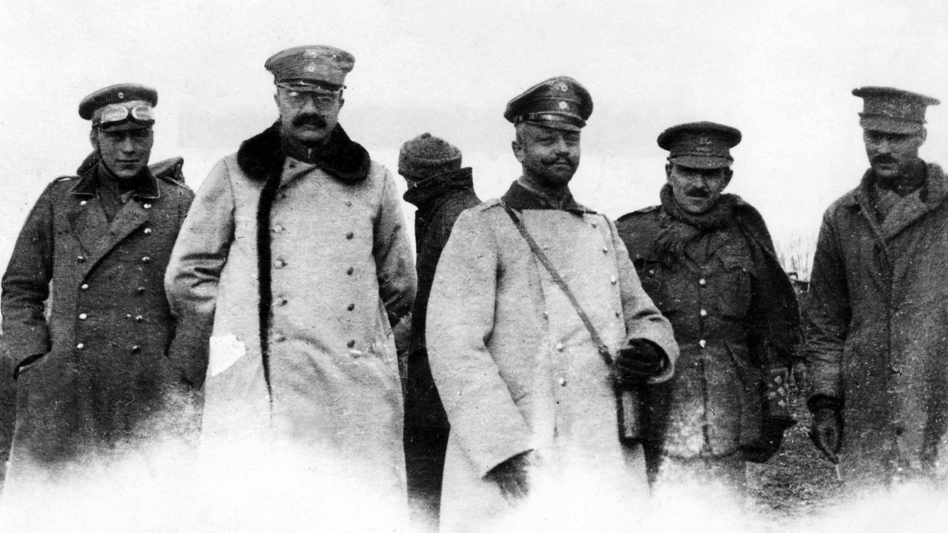 Schwarz-weiß-Foto deutscher und britischer Offiziere im Niemandsland während des inoffiziellen Waffenstillstands an Weihnachten 1914 im Ersten Weltkrieg. Sie stehen nebeneinander und schauen in die Kamera. Schwarz-weiß-Foto deutscher und britischer Offiziere im Niemandsland während des inoffiziellen Waffenstillstands an Weihnachten 1914 im Ersten Weltkrieg. Sie stehen nebeneinander und schauen in die Kamera.