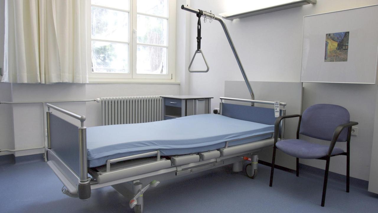 Leeres Krankhausbetten in einem großen Krankenzimmer mit blauem Fußboden. Leeres Krankhausbetten in einem großen Krankenzimmer mit blauem Fußboden.