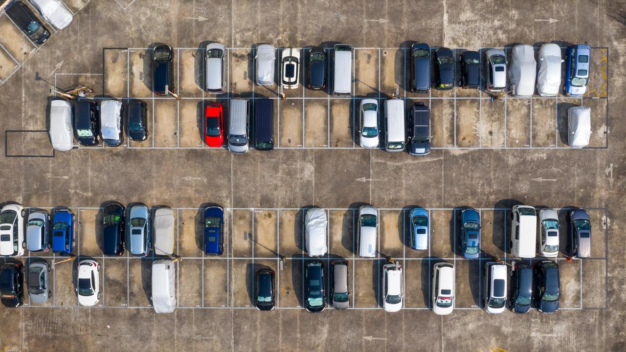 Aufsicht auf einen Parkplatz mit vielen Autos.