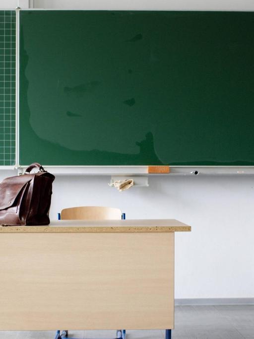 Eine leere Schultafel und eine Schultasche.