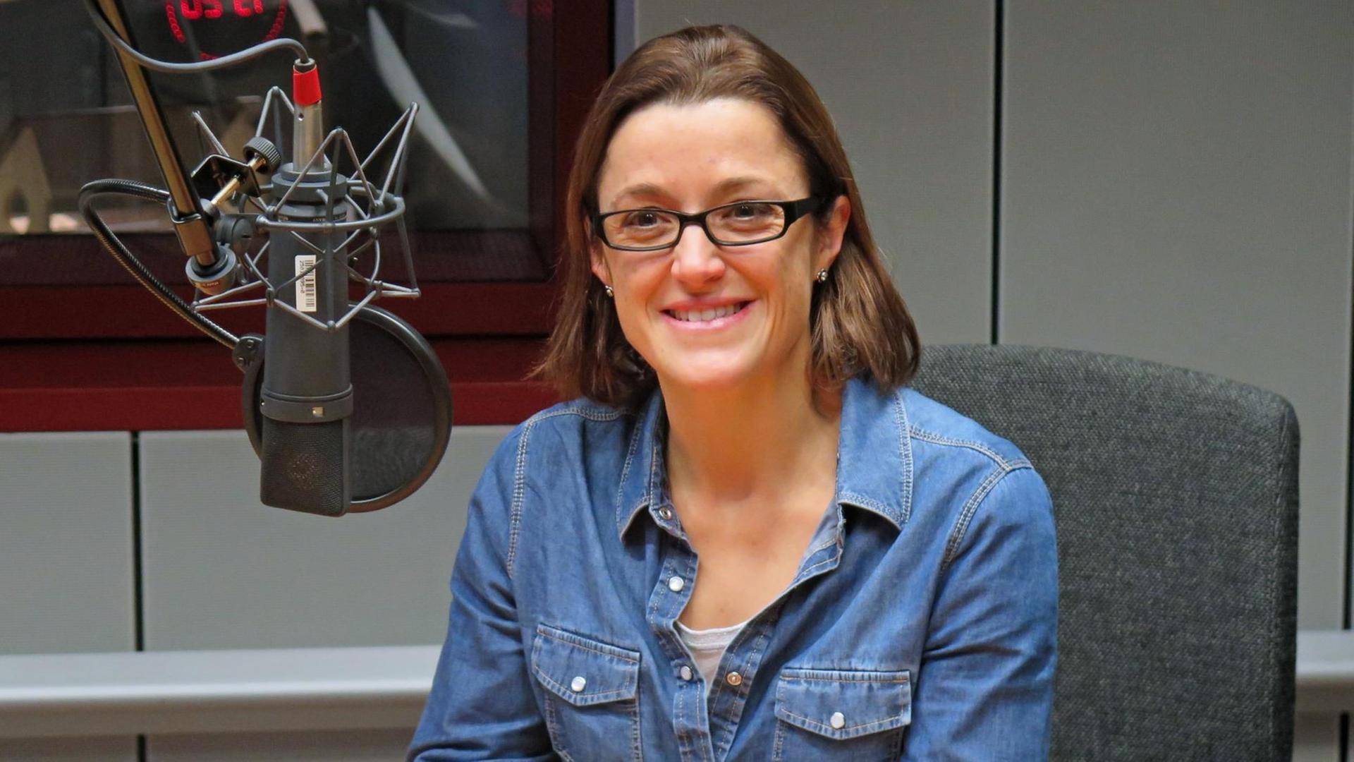 Ninja Charbonneau, Pressesprecherin von Unicef Deutschland sitzt an einem Tisch im Aufnahmestudio Ninja Charbonneau, Pressesprecherin von Unicef Deutschland sitzt an einem Tisch im Aufnahmestudio