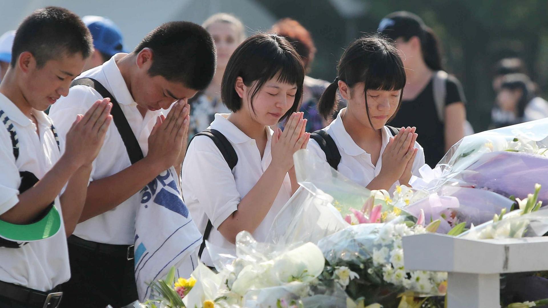 Junge Menschen gedenken zum 70. Jahrestag des Abwurfs einer US-Atombombe über Hiroshima der Opfer.