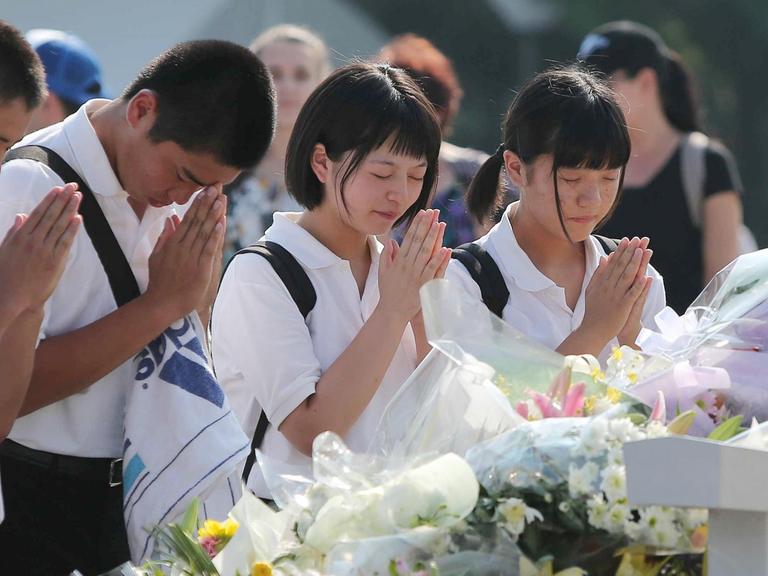 Junge Menschen gedenken zum 70. Jahrestag des Abwurfs einer US-Atombombe über Hiroshima der Opfer.