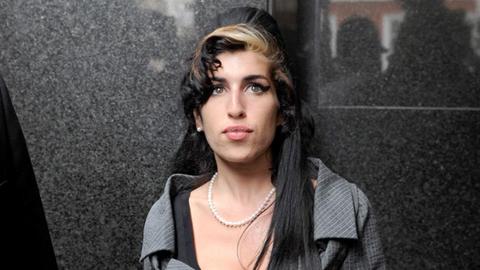 Amy Winehouse vor eine Marmorwand