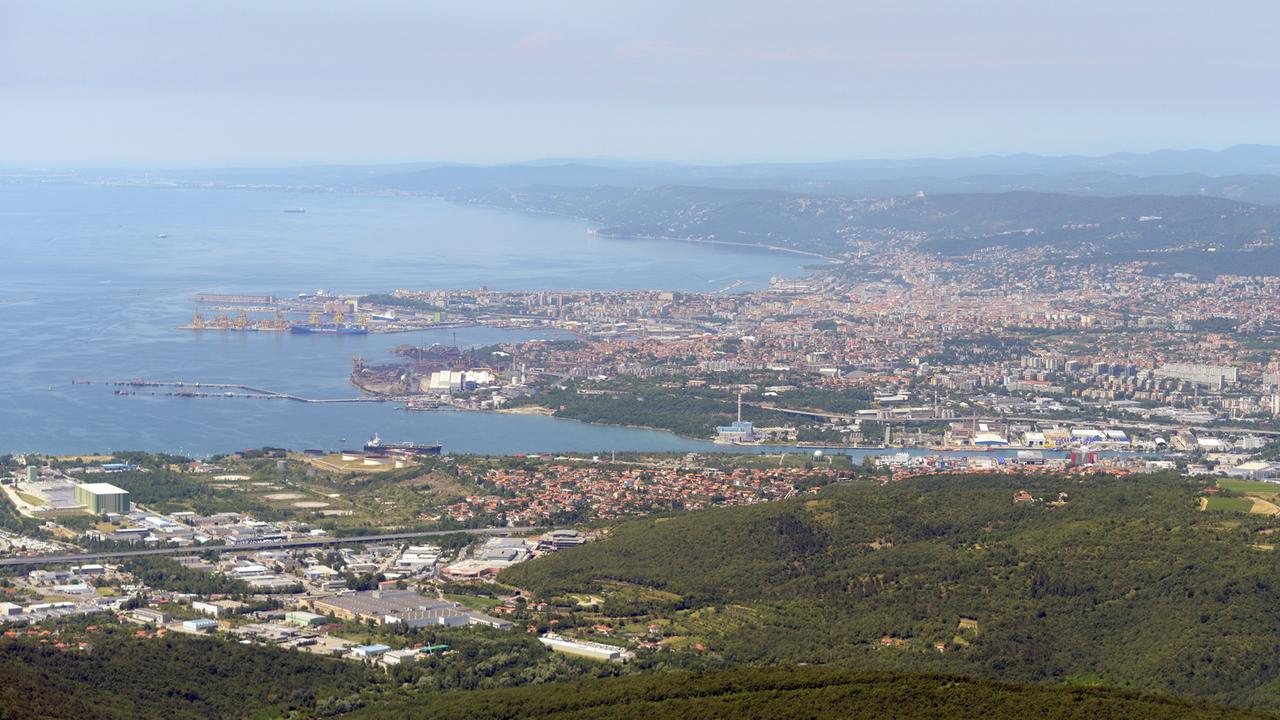 Luftbildaufnahme aus südlicher Richtung von Triest mit den Hafenanlagen