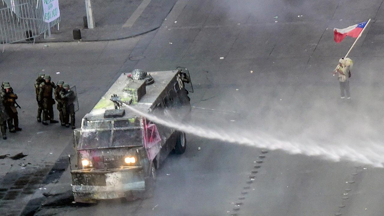 Ein einzelner Mann steht auf der Straße und demonstriert vor einem Fahrezug der Polizei. Ein einzelner Mann steht auf der Straße und demonstriert vor einem Fahrezug der Polizei.