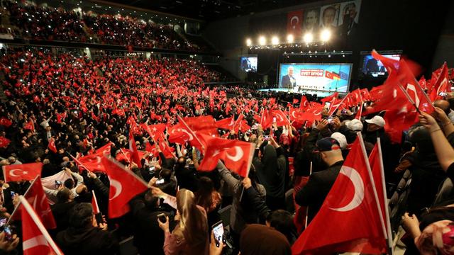 Teilnehmer bei einer Veranstaltung mit dem türkischen Ministerpräsidenten Yildirim in Oberhausen halten türkische Fahnen in den Händen.