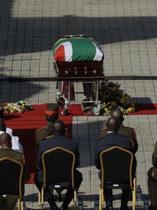 14.04.2018, Südafrika, Soweto: Der Sarg mit dem Leichnam der verstorbenen Anti-Apartheidskämpferin Winnie Madikizela-Mandela steht im Orlando-Stadion während des Staatsbegräbnisses. Winnie Madikizela-Mandela war nach langer Krankheit am 02.04.2018 im Alter von 81 Jahren gestorben.
