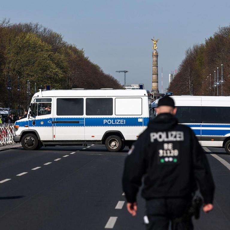Einsatzkräfte der Polizei stehen auf der Straße des 17. Juni. 