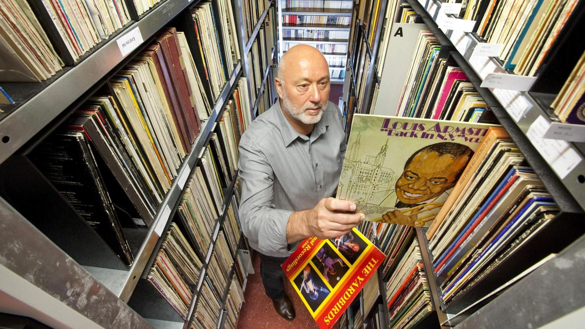 Reinhard Lorenz, Gründer des Internationalen Jazz Archivs Eisenach, zieht eine Platte von Louis Armstrong aus der Schallplattensammlung. Reinhard Lorenz, Gründer des Internationalen Jazz Archivs Eisenach, zieht eine Platte von Louis Armstrong aus der Schallplattensammlung.