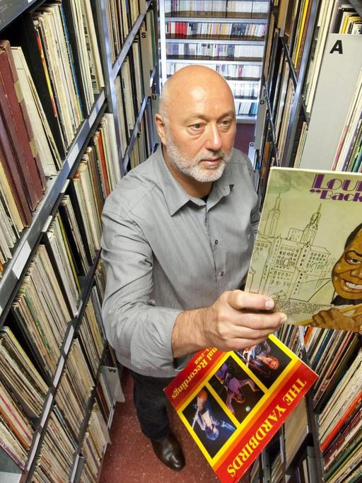 Reinhard Lorenz, Gründer des Internationalen Jazz Archivs Eisenach, zieht eine Platte von Louis Armstrong aus der Schallplattensammlung.