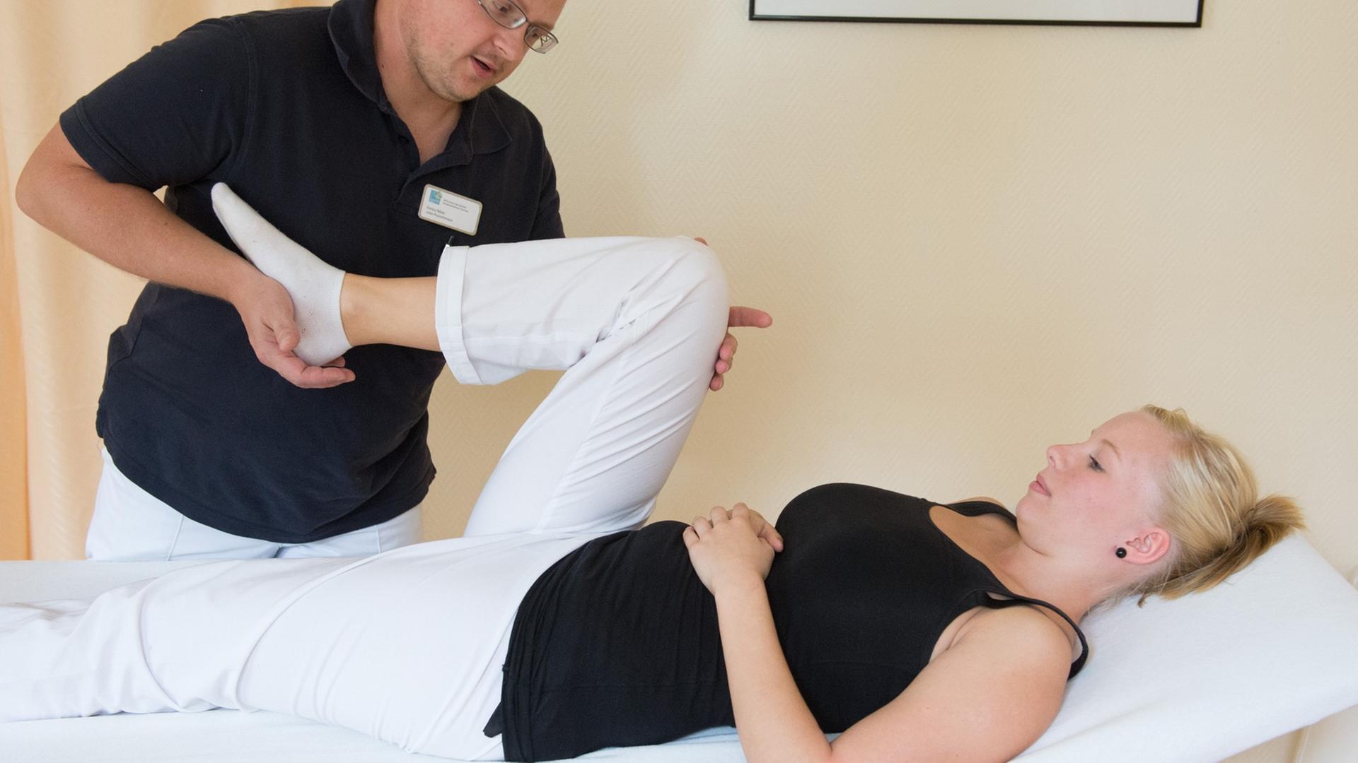 Ein Physiotherapeut behandelt Knieprobleme einer jungen Patientin. Ein Physiotherapeut behandelt Knieprobleme einer jungen Patientin.