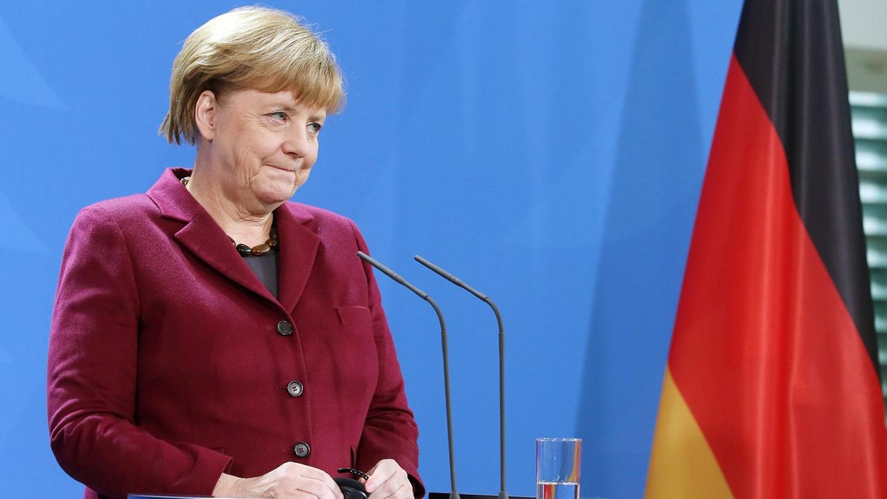 Angela Merkel spricht auf einer Presse-Konferenz. Neben ihr steht eine Deutschland-Fahne. 