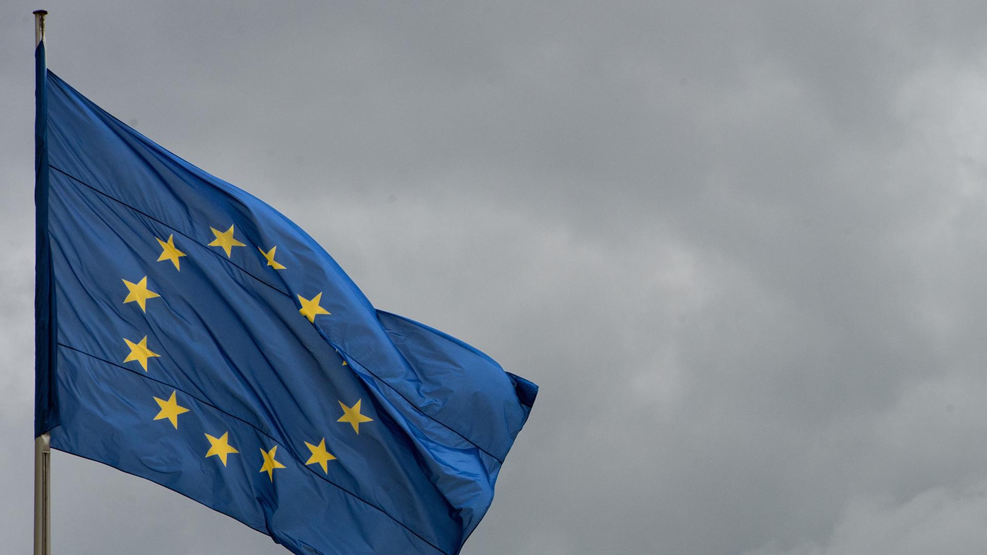 Die Flagge der Europäischen Union weht vor wolkenverhangenem Himmel. Die Flagge der Europäischen Union weht vor wolkenverhangenem Himmel.