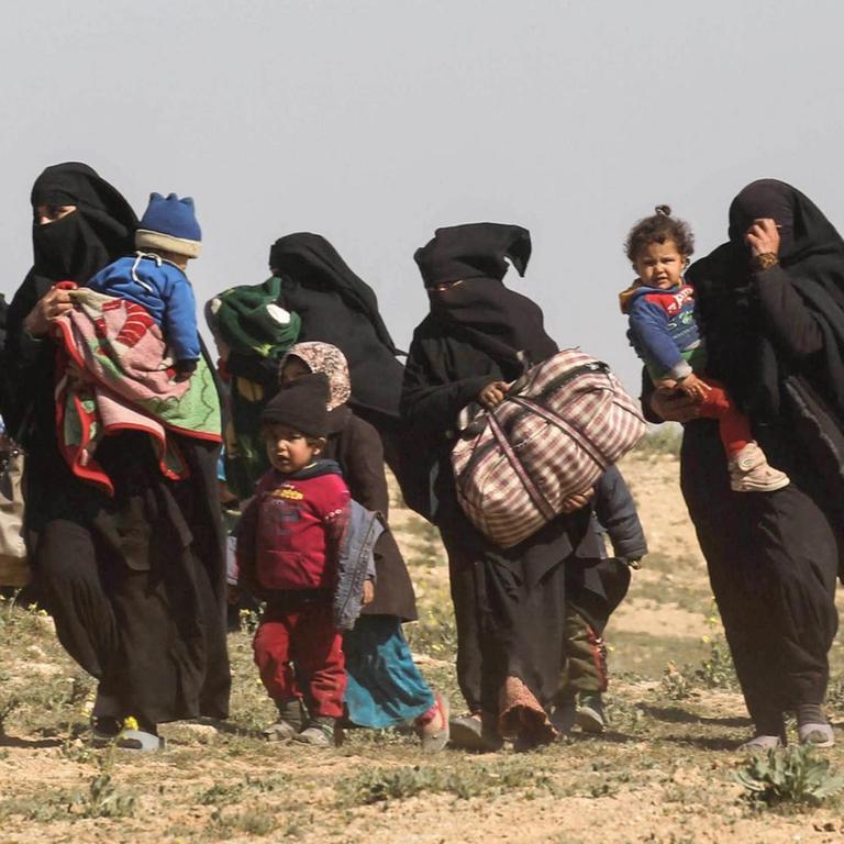 Frauen fliehen mit ihren Kindern aus dem IS-Dorf Baghus im Osten des Landes. 