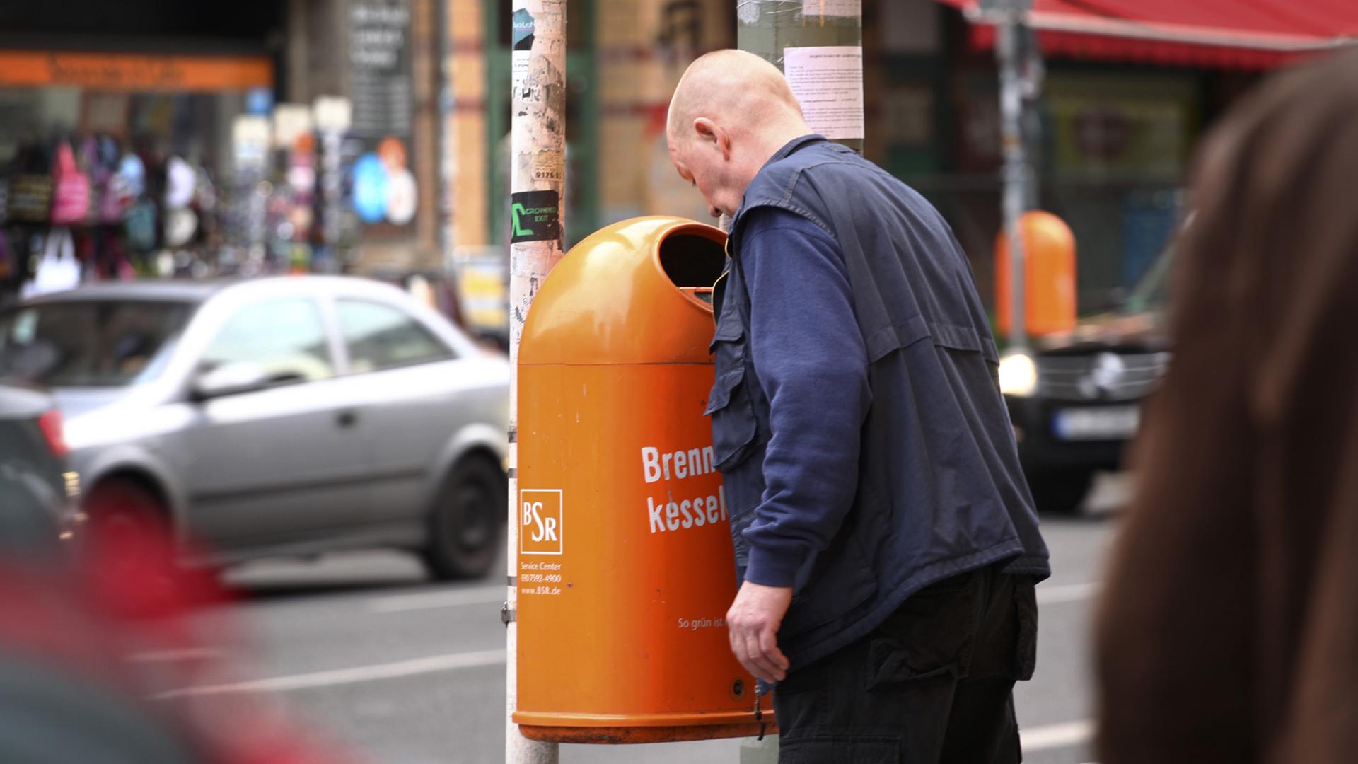 Ein Mann sucht in Berlin in einem Papierkorb nach Pfandflaschen oder Pfanddosen. Ein Mann sucht in Berlin in einem Papierkorb nach Pfandflaschen oder Pfanddosen.