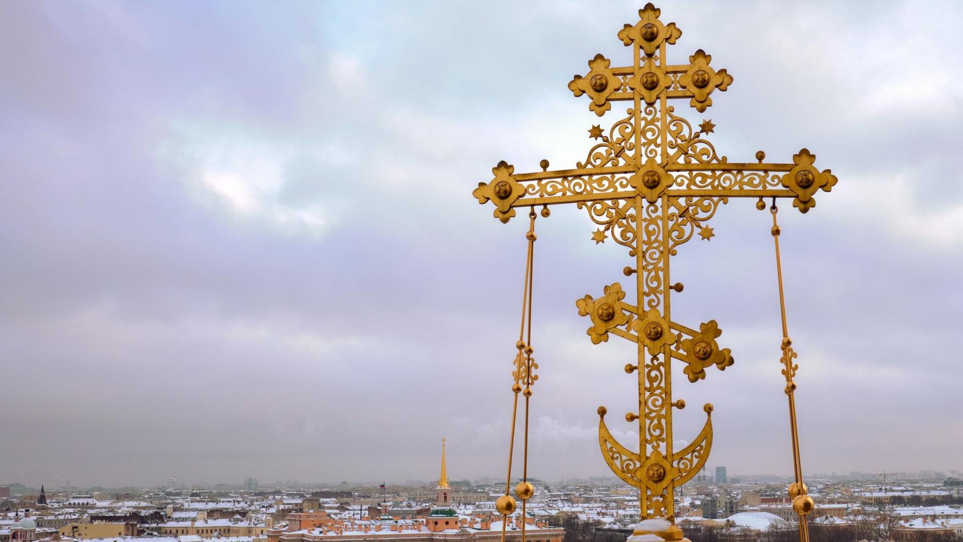 Das Kreuz der Auferstehungskirche in St. Petersburg ist vor dem Panorama der Stadt zu sehen. Das Kreuz der Auferstehungskirche in St. Petersburg ist vor dem Panorama der Stadt zu sehen.