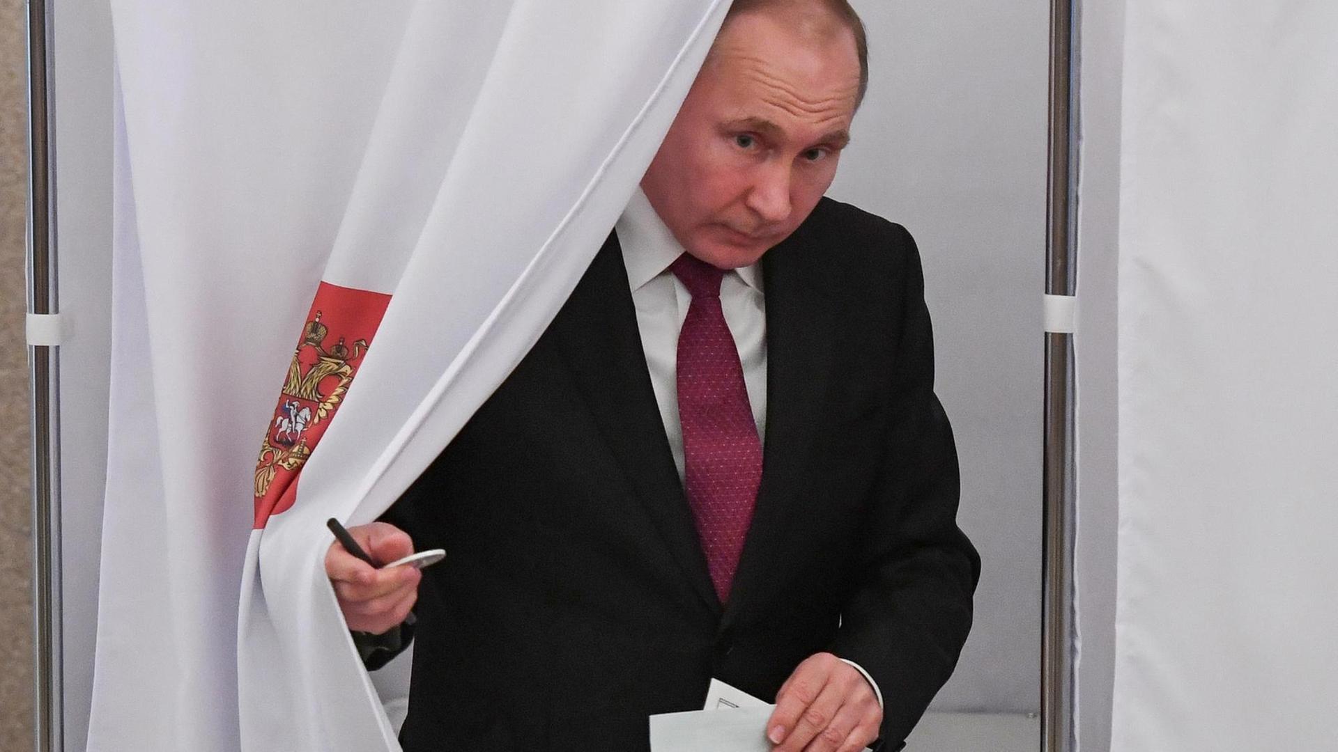Wladimir Putin kommt am 18.03.2018 aus der Wahlkabine seines Wahllokals in Moskau, nachdem er seine Stimme für die Präsidentschaftswahl abgegeben hat.