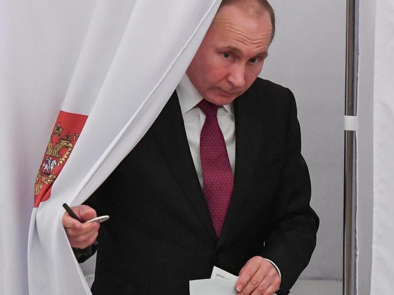 Wladimir Putin kommt am 18.03.2018 aus der Wahlkabine seines Wahllokals in Moskau, nachdem er seine Stimme für die Präsidentschaftswahl abgegeben hat.
