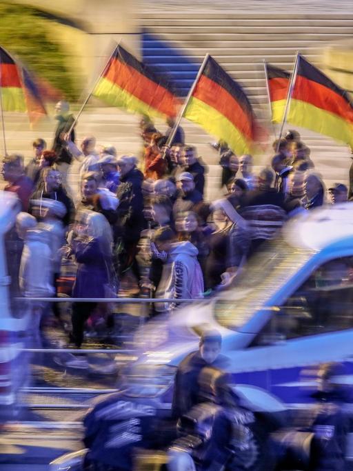 Teilnehmer einer Demonstration der rechtspopulistischen Bewegung Pro Chemnitz ziehen mit Deutschlandfahnen durch die Stadt.