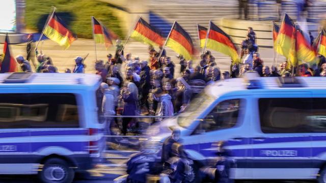Teilnehmer einer Demonstration der rechtspopulistischen Bewegung Pro Chemnitz ziehen mit Deutschlandfahnen durch die Stadt.