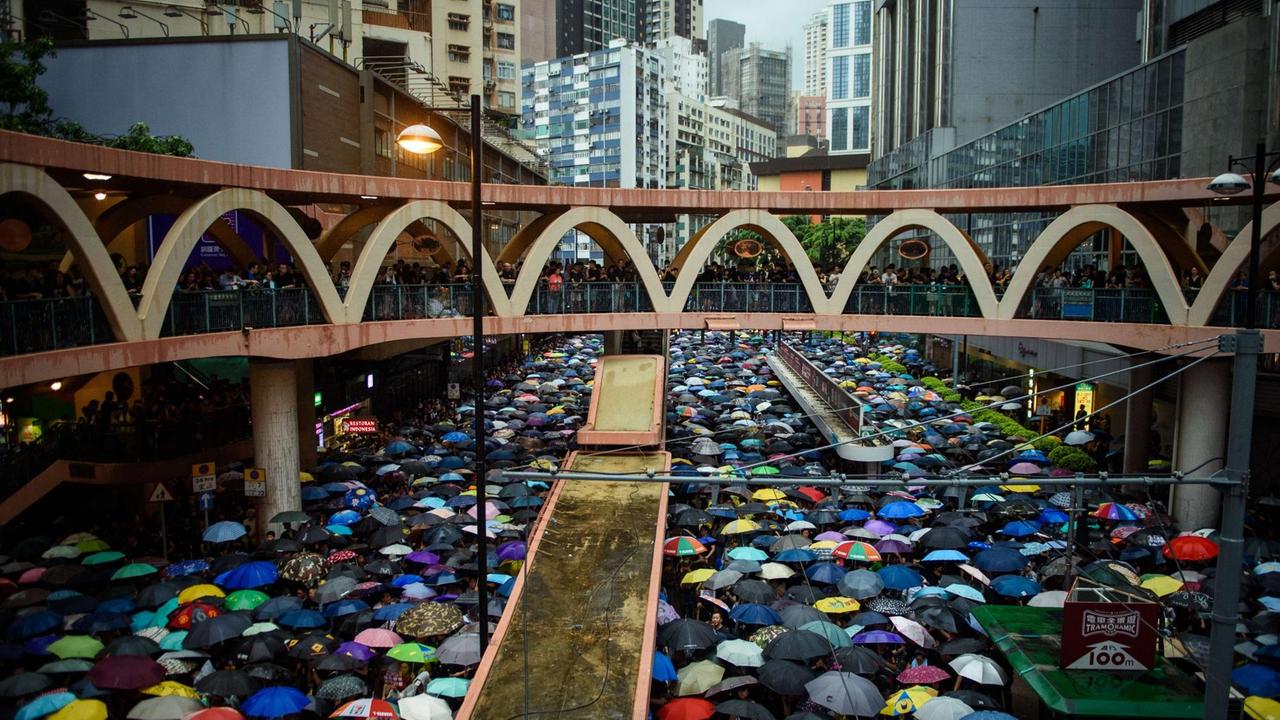 Demonstranten schützen sich am 18.8.2019 mit Schirmen vor dem anhaltenden Regen, die gleichzeitig ein Symbol des Protests sind. Demonstranten schützen sich am 18.8.2019 mit Schirmen vor dem anhaltenden Regen, die gleichzeitig ein Symbol des Protests sind.