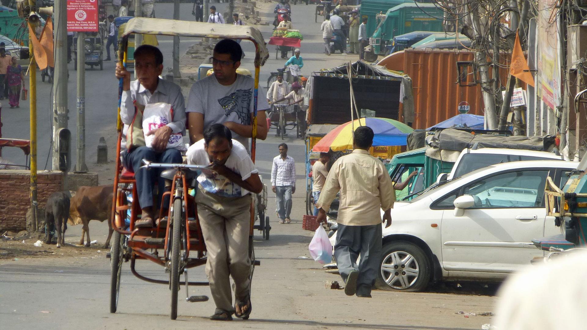 Alltag in Old Delhi: Ein Mann zieht eine Rikscha samt Passagieren. Alltag in Old Delhi: Ein Mann zieht eine Rikscha samt Passagieren.
