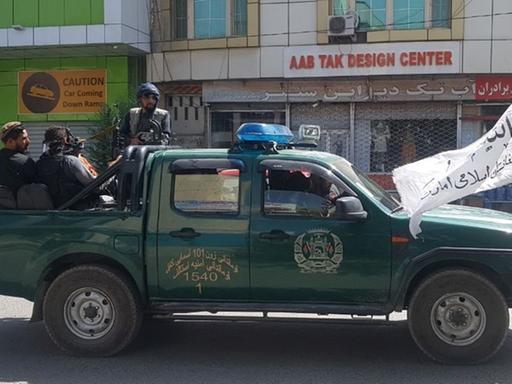 Taliban-Streife in Kabul: Mehrere Kämpfer sitzen auf einem Pick-up-Truck.