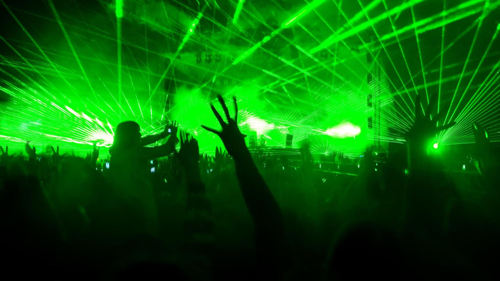 Eine Lasershow hüllt eine Konzerthalle in grünes Licht. Eine Lasershow hüllt eine Konzerthalle in grünes Licht.