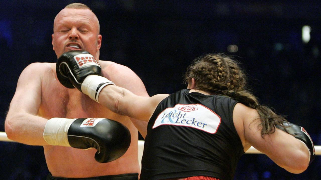 Das Bild zeigt, wie Boxweltmeisterin Regina Halmich (r) Moderator Stefan Raab gezielt einen Boxhieb versetzt.