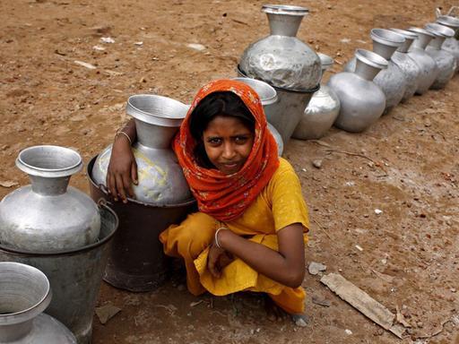 Ein Mädchen in Bangladesch wartet auf Trinkwasser.
