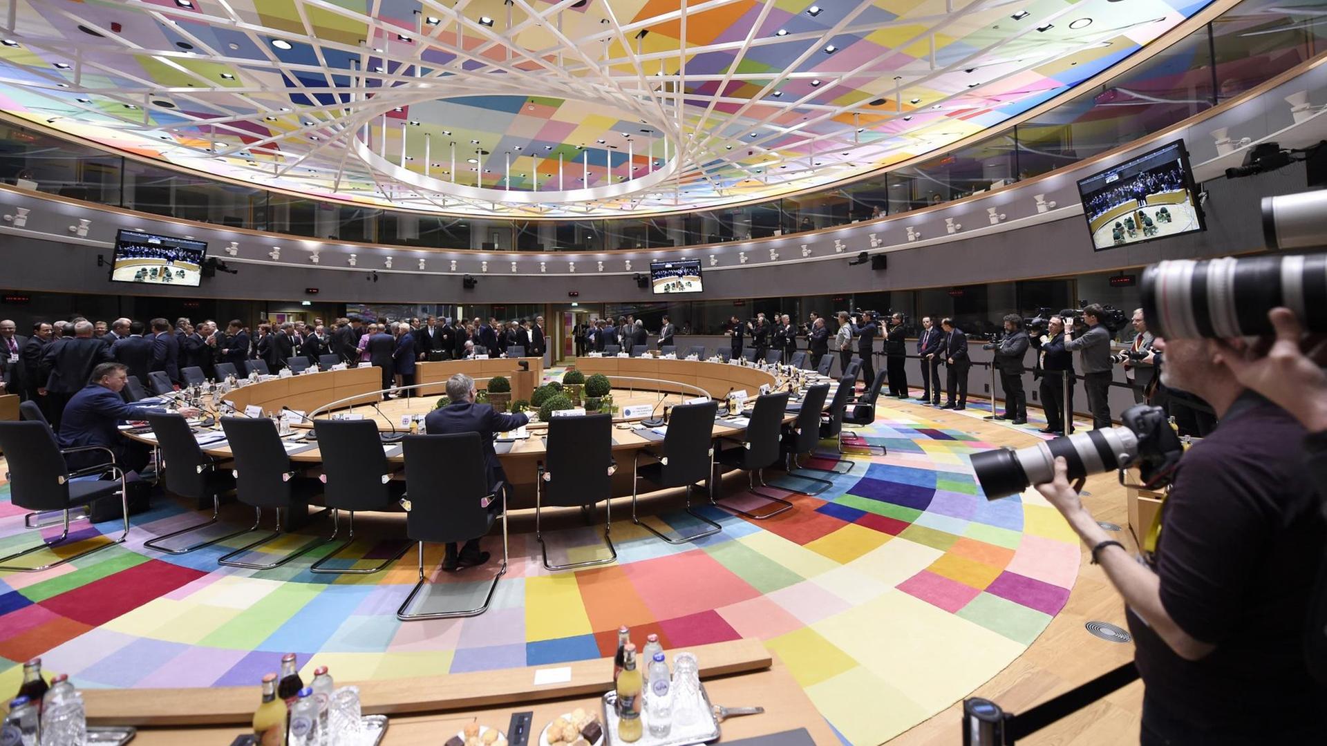Ein Blick auf den beginnenden EU-Gipfel: Man sieht den runden Tisch und bunte Farben auf dem Boden und an der Decke. Ein Blick auf den beginnenden EU-Gipfel: Man sieht den runden Tisch und bunte Farben auf dem Boden und an der Decke.