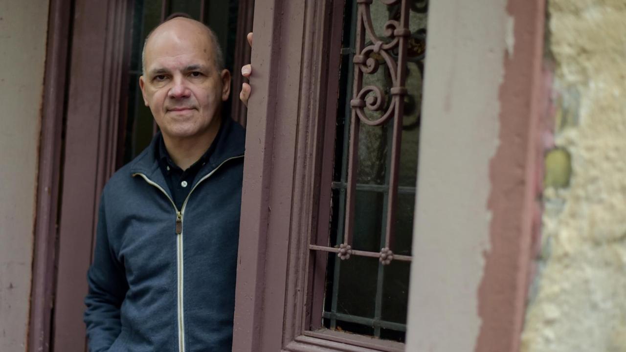 Der Schriftsteller Frank Witzel steht lässig in einem Hauseingang und blickt auf die Straße Der Schriftsteller Frank Witzel steht lässig in einem Hauseingang und blickt auf die Straße