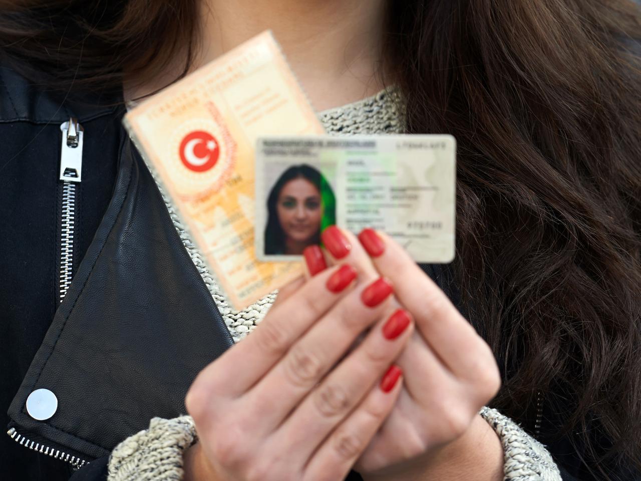 Junge Frau mit deutschem und türkischem Personalausweis Junge Frau mit deutschem und türkischem Personalausweis
