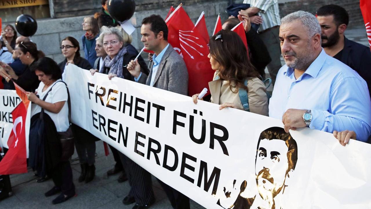 Kritiker der Türkischen Regierung demonstrieren im September 2018 in Berlin für die Freilassung des Journalisten Eren Erdem. Vor sich tragen sie ein Transparent mit der Aufschrift "Freiheit für Eren Erdem" und einem Bild von ihm. Kritiker der Türkischen Regierung demonstrieren im September 2018 in Berlin für die Freilassung des Journalisten Eren Erdem. Vor sich tragen sie ein Transparent mit der Aufschrift "Freiheit für Eren Erdem" und einem Bild von ihm.