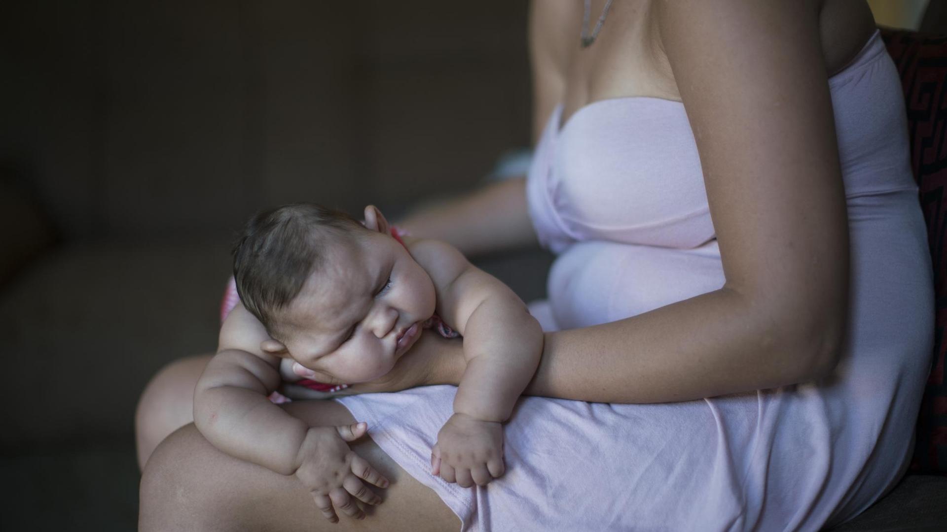 Eine Frau in Recife in Brasilien hält ihr Baby, das durch Mikrozephalie eine Schädelfehlbildung aufweist. Eine Frau in Recife in Brasilien hält ihr Baby, das durch Mikrozephalie eine Schädelfehlbildung aufweist.