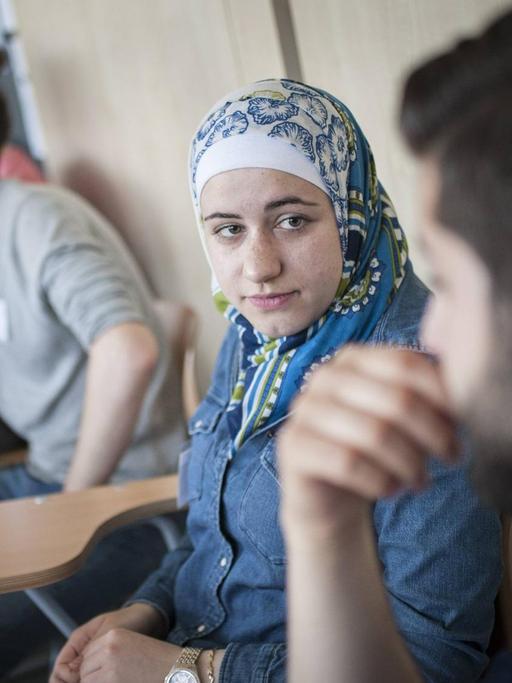 Flüchtlinge - eine junge Frau und mehrere Männer - nehmen an einem Vorbereitungs-Kurs an der Freien Universität in Berlin teil.