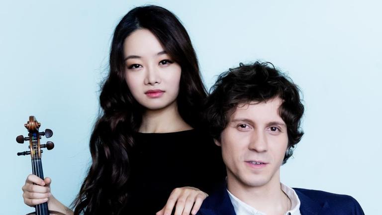 Die koreanische Geigerin Bomsori Kim und der polnische Pianist Rafal Blechacz sind schwarzgekleidet im Halbporträt zu sehen.